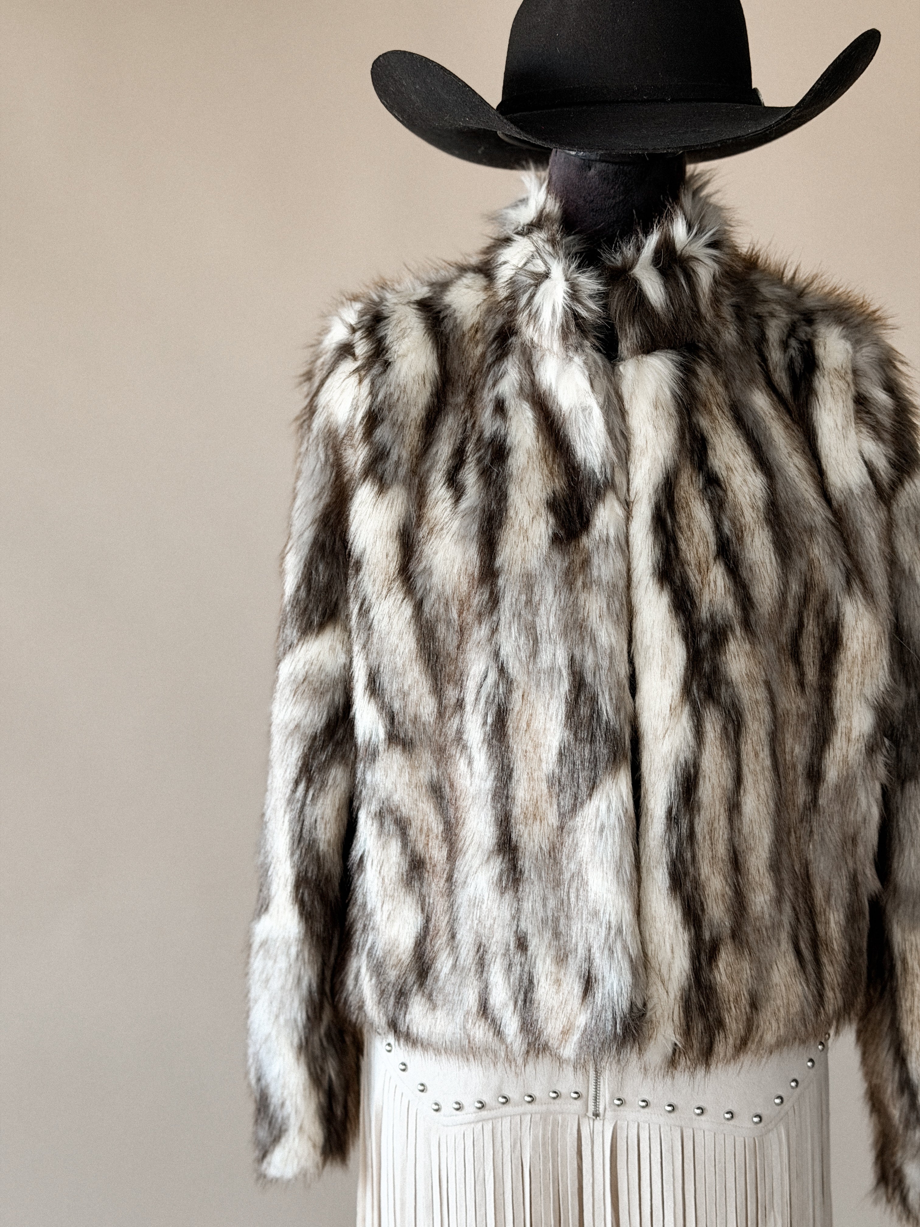 Western faux fur jacket with fringe skirt and black cowboy hat, boho cowgirl style