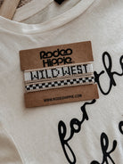 Thunderbird pendant chain necklace displayed on wooden slab with serape fabric underneath - The Wild J