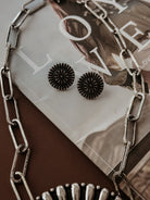 Thunderbird pendant chain necklace displayed on wooden slab with serape fabric underneath - The Wild J