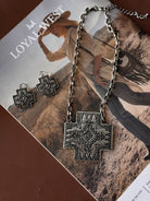 Thunderbird pendant chain necklace displayed on wooden slab with serape fabric underneath - The Wild J