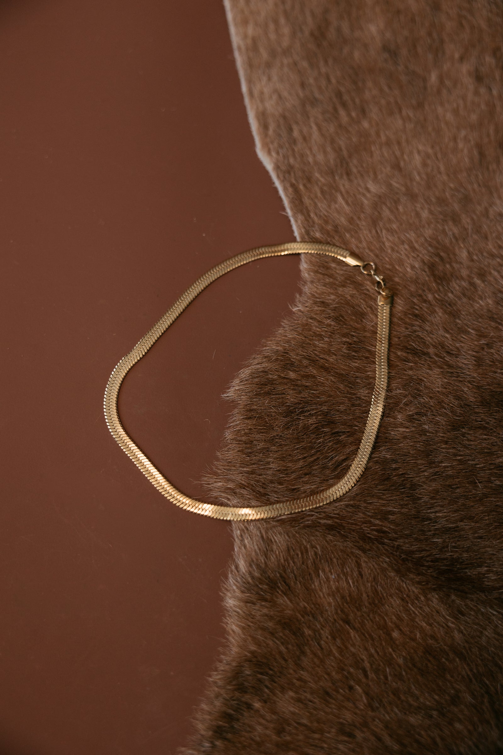 Gold‑plated herringbone chain necklace with a high‑shine finish.