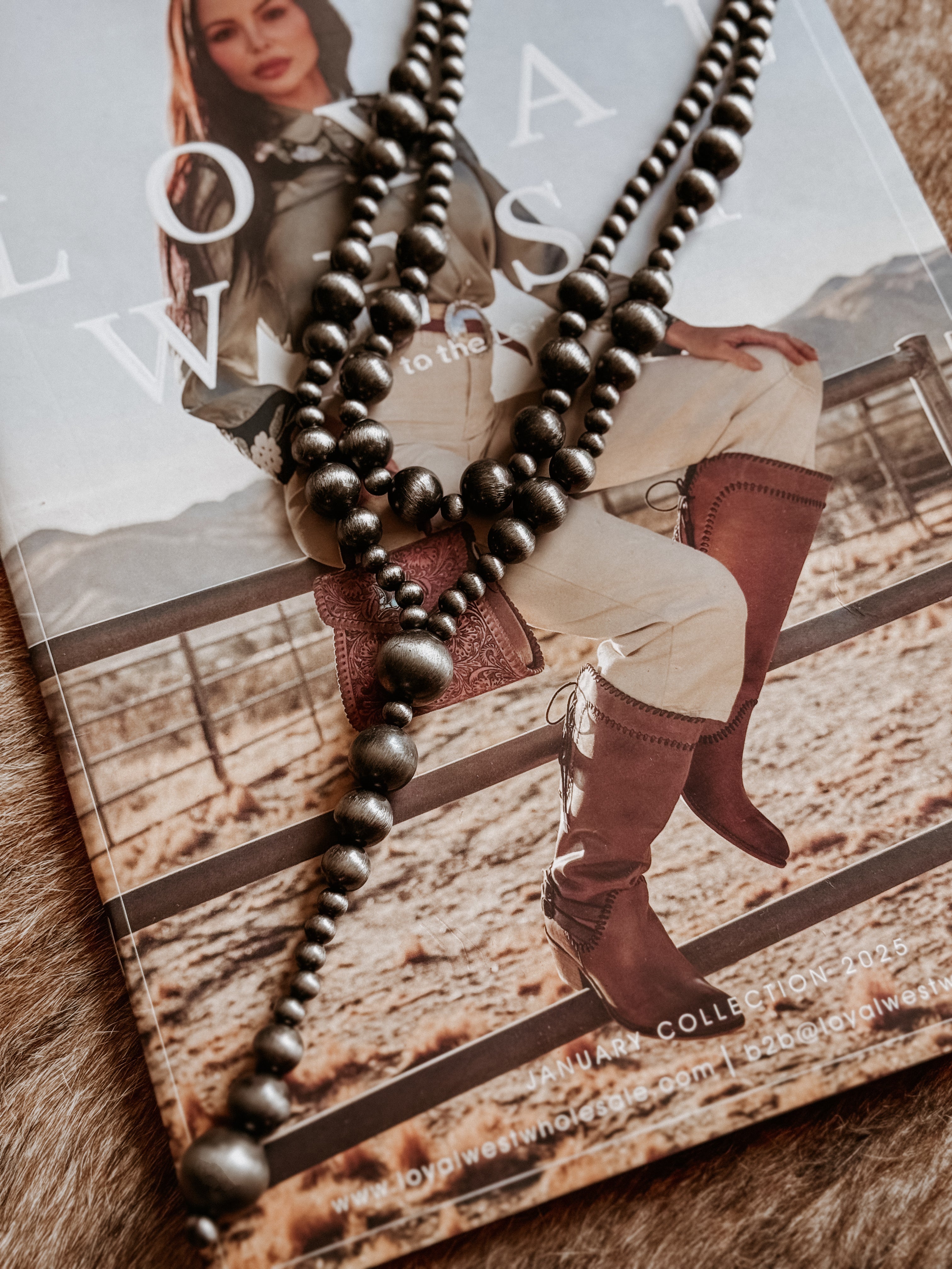 Thunderbird pendant chain necklace displayed on wooden slab with serape fabric underneath - The Wild J