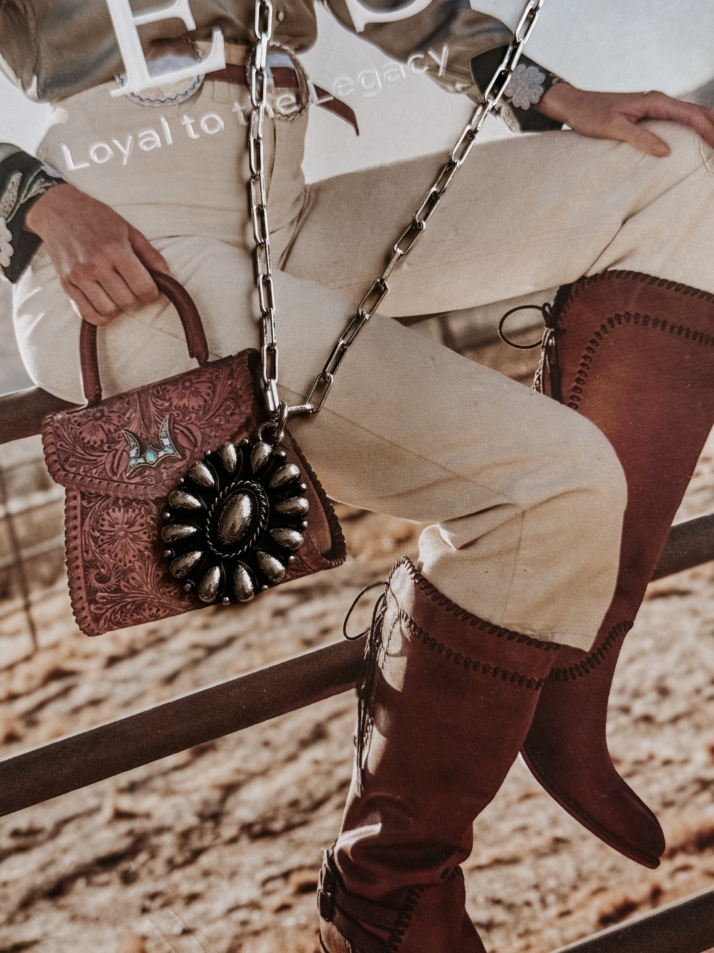 Thunderbird pendant chain necklace displayed on wooden slab with serape fabric underneath - The Wild J