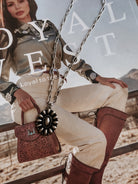 Thunderbird pendant chain necklace displayed on wooden slab with serape fabric underneath - The Wild J