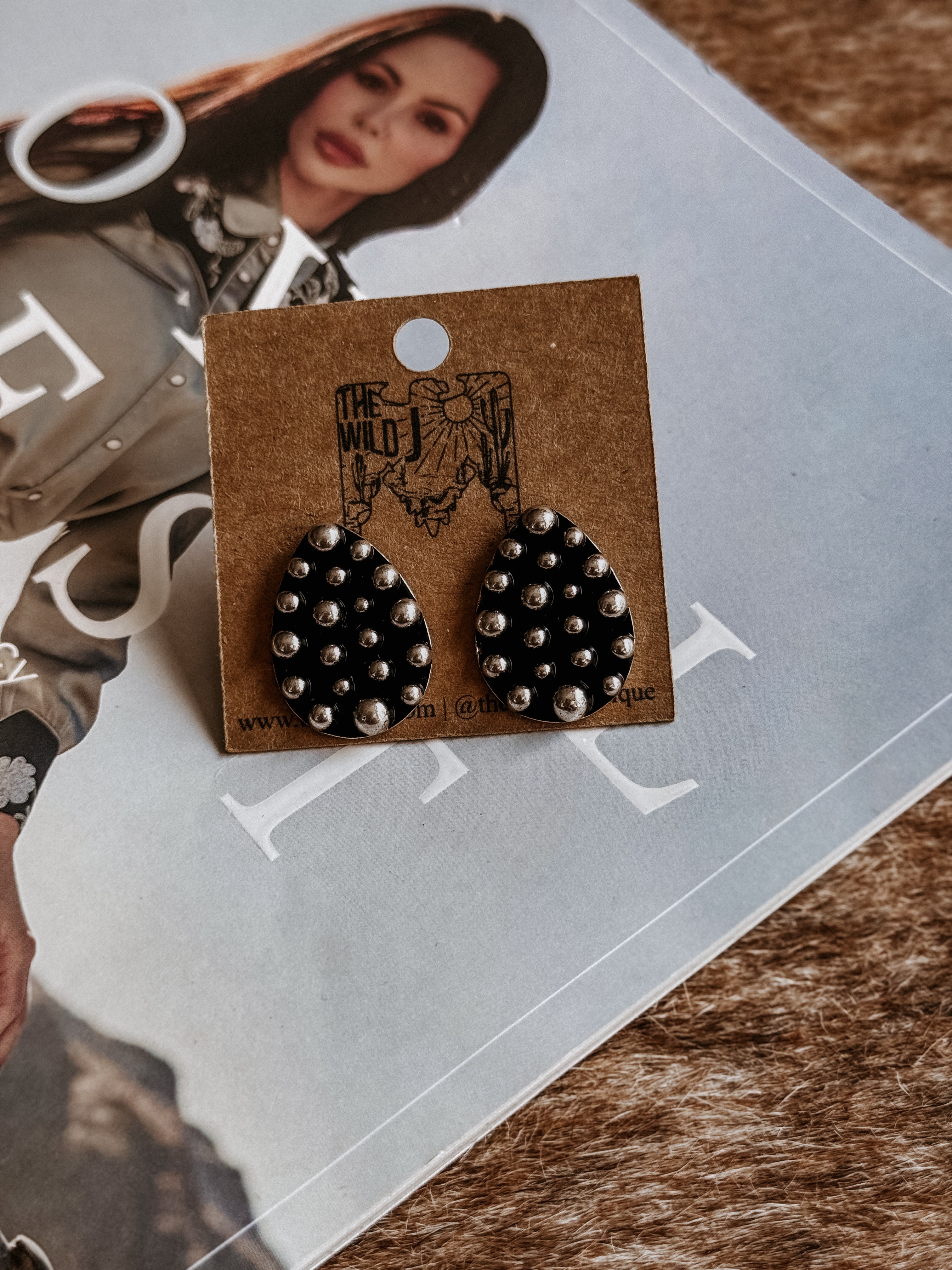 Thunderbird pendant chain necklace displayed on wooden slab with serape fabric underneath - The Wild J