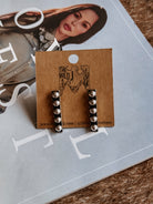 Thunderbird pendant chain necklace displayed on wooden slab with serape fabric underneath - The Wild J