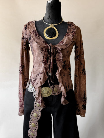 Mannequin wearing a brown patterned top with decorative belt and necklace on a plain background