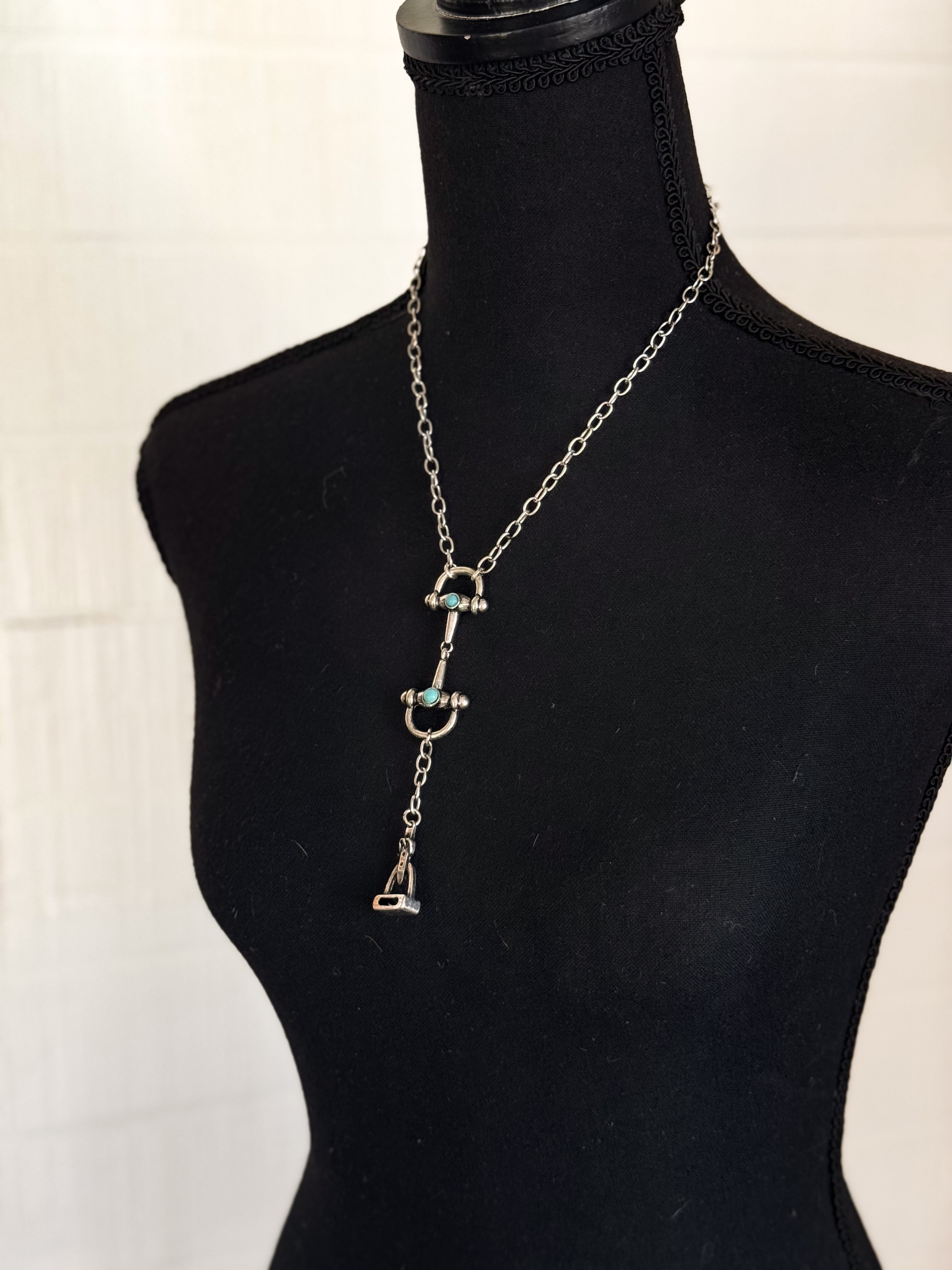 Thunderbird pendant chain necklace displayed on wooden slab with serape fabric underneath - The Wild J