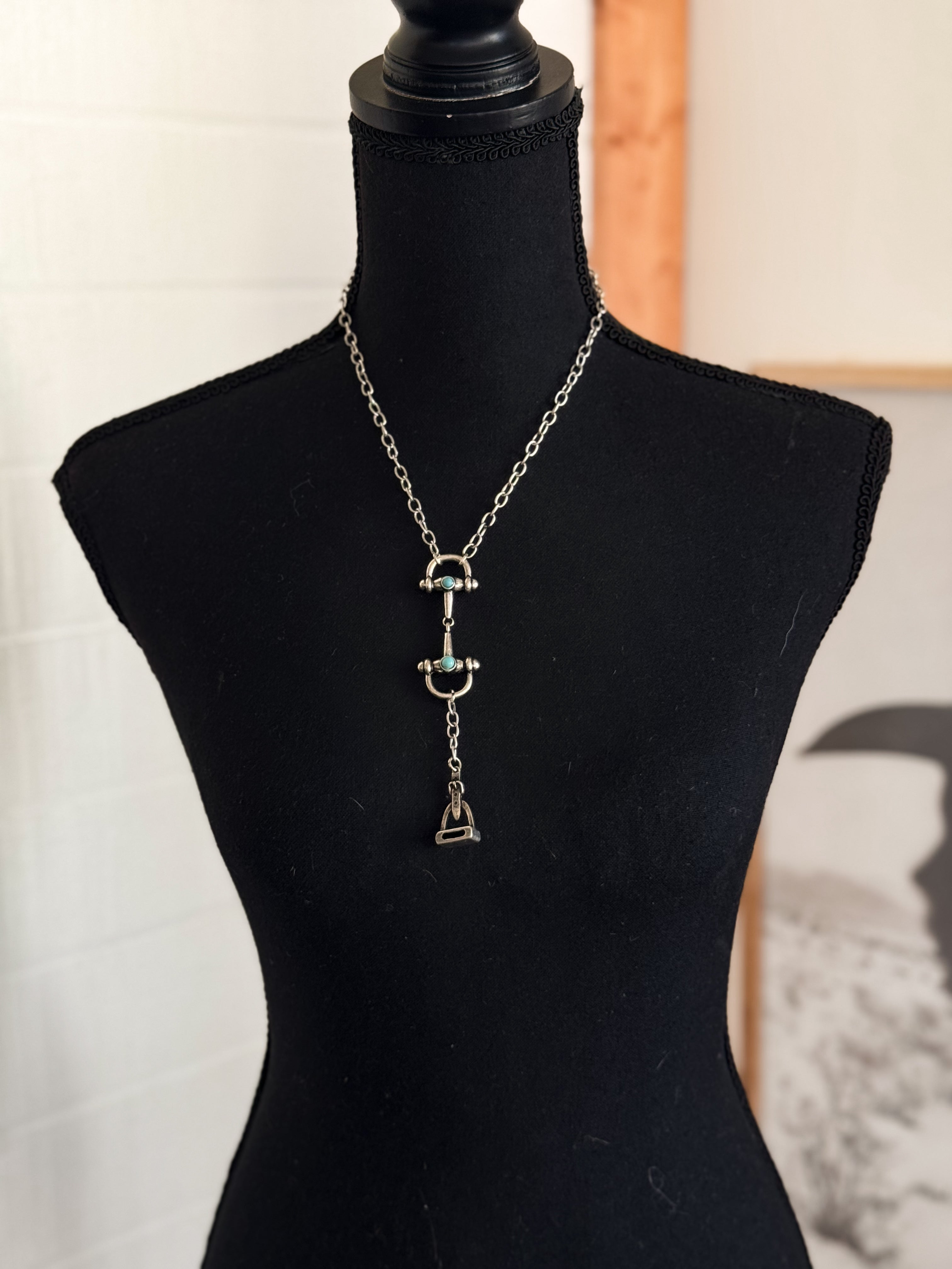 Thunderbird pendant chain necklace displayed on wooden slab with serape fabric underneath - The Wild J