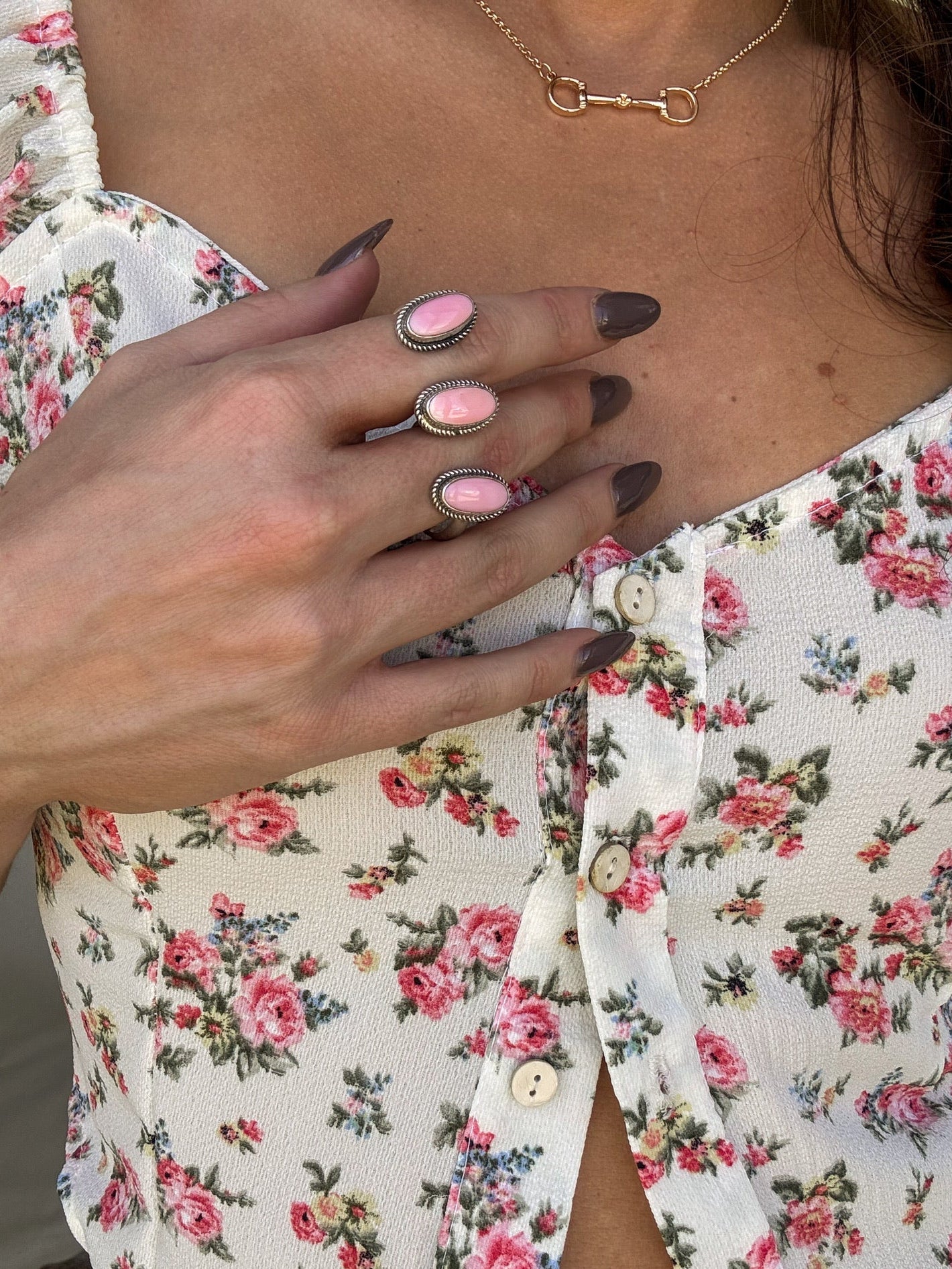 Triple pink conch statement ring on hand, floral blouse, western boho jewelry style