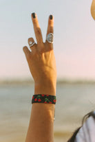 Thunderbird pendant chain necklace displayed on wooden slab with serape fabric underneath - The Wild J