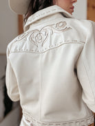 Woman wearing cream western leather jacket with floral embroidery and stitched details