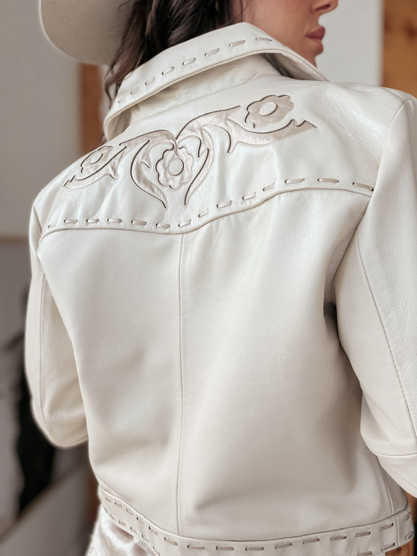 Woman wearing cream western leather jacket with floral embroidery and stitched details