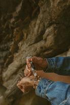 Thunderbird pendant chain necklace displayed on wooden slab with serape fabric underneath - The Wild J
