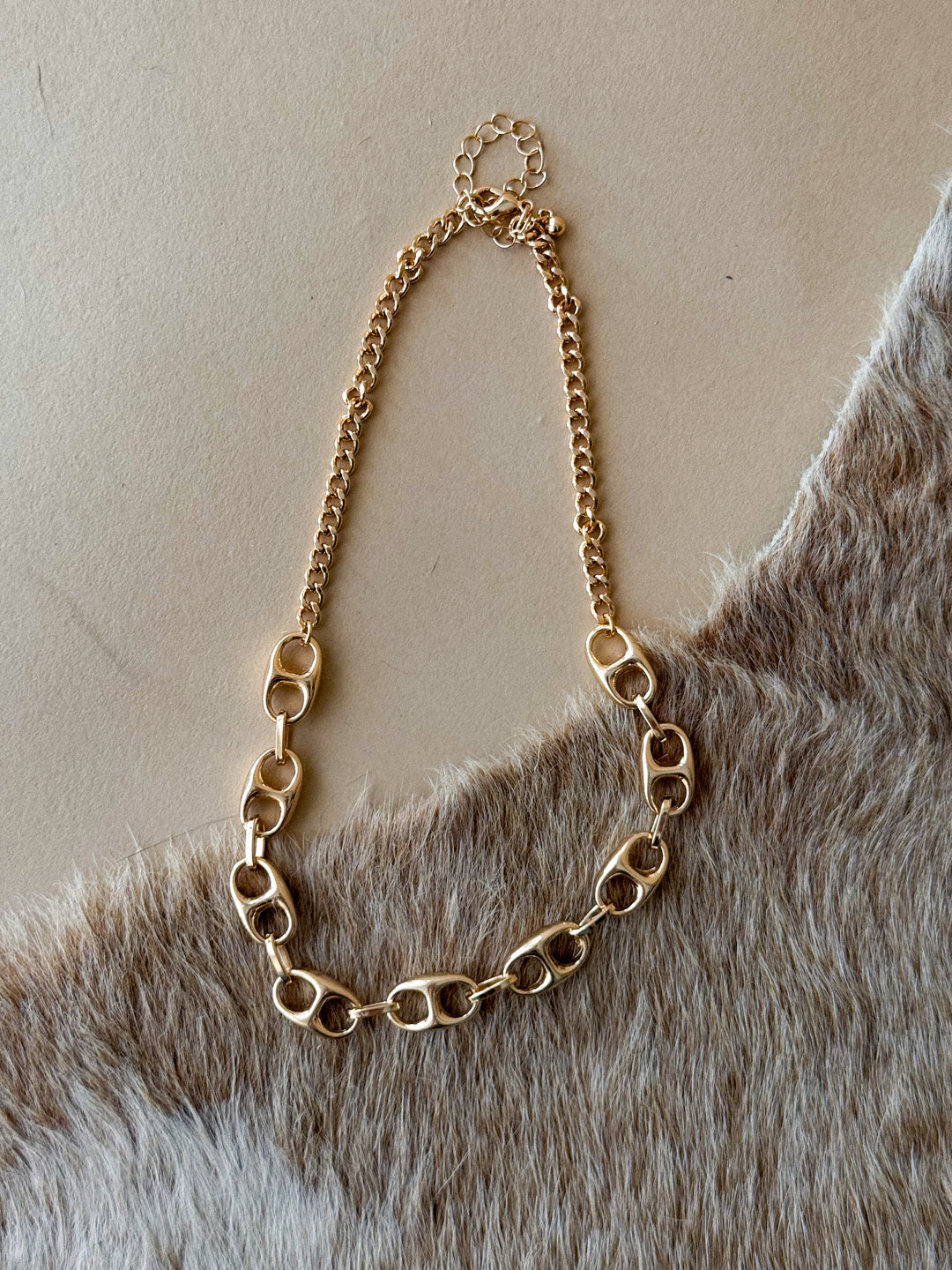 Gold metal link necklace with sculptural chain design