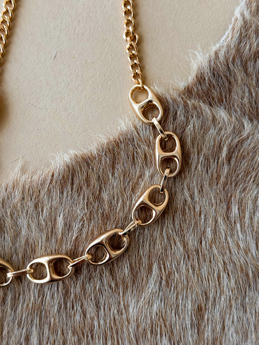 Gold chain necklace on a fur surface