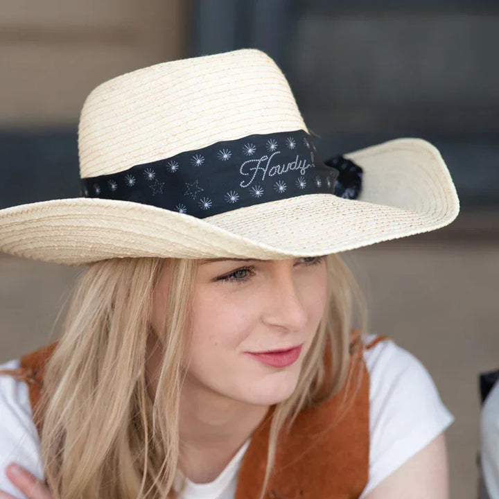 Woman wearing a wide-brimmed hat with a black &