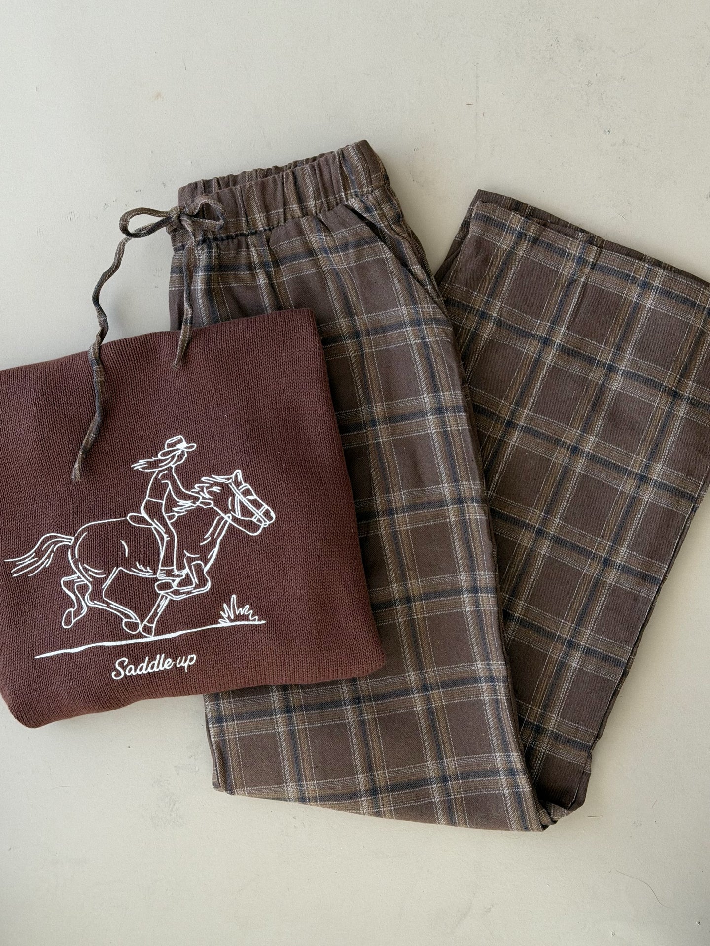 Dusty brown plaid wide-leg pajama pants shown folded