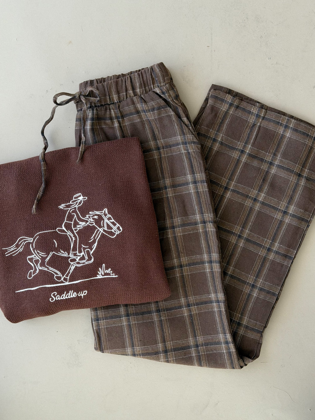 Dusty brown plaid wide-leg pajama pants shown folded