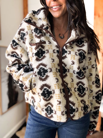 Person wearing a patterned fleece jacket indoors