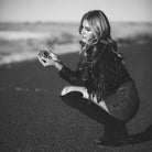 woman wearing fringe leather jacket holding bottle of Smokeshow perfume