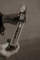 Thunderbird pendant chain necklace displayed on wooden slab with serape fabric underneath - The Wild J