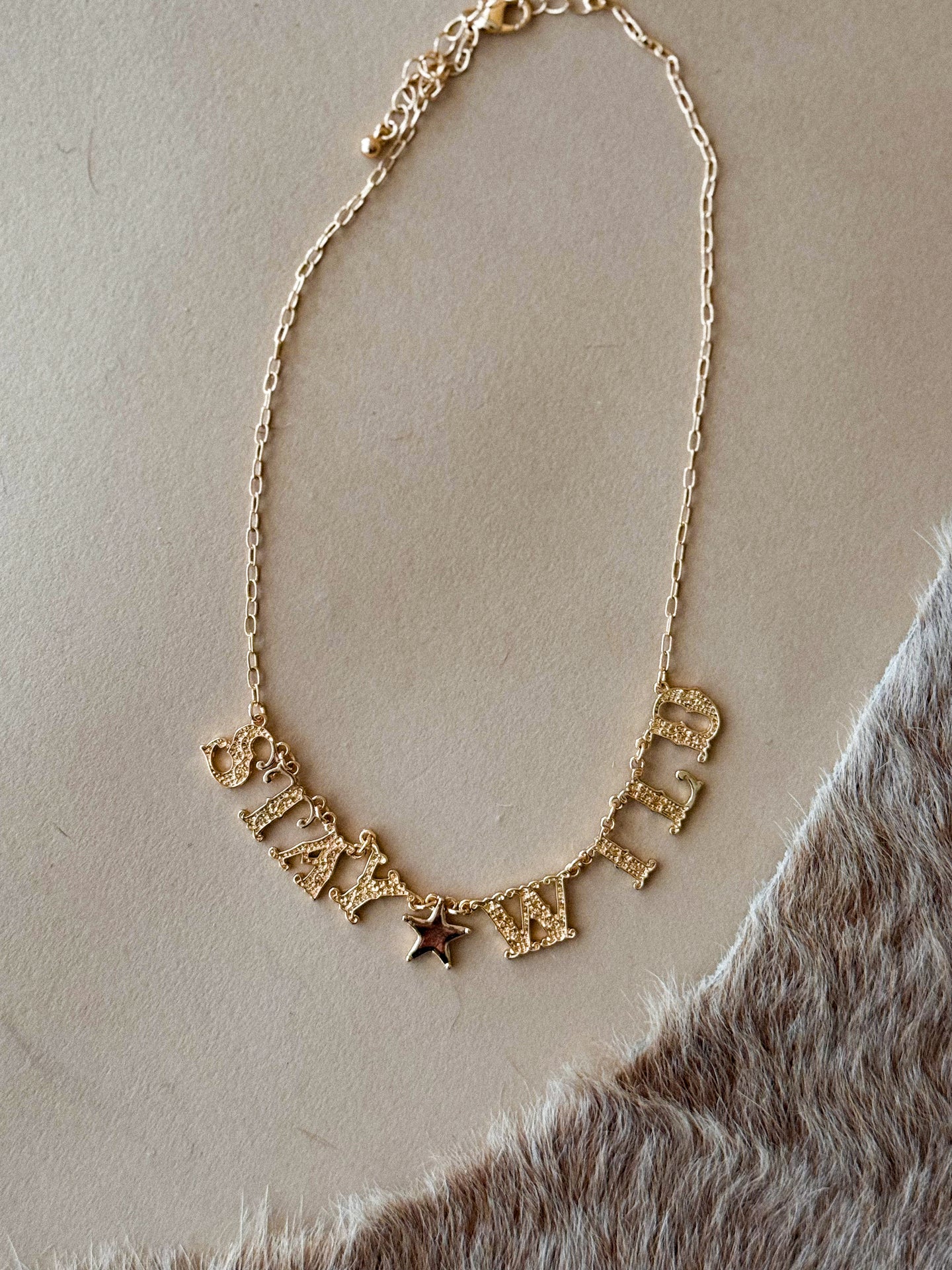 Gold ‘Stay Wild’ charm necklace with star detail
