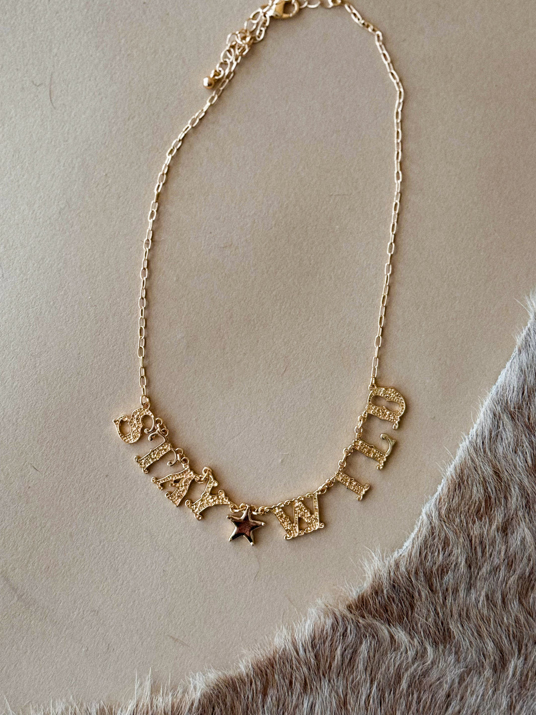 Gold ‘Stay Wild’ charm necklace with star detail