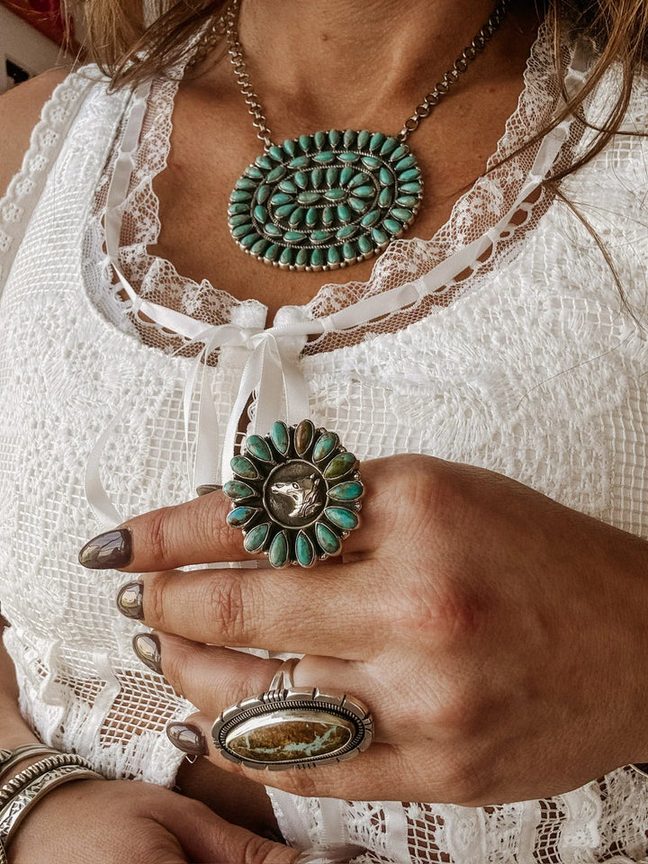 Cowgirl wearing a turquoise squash blossom necklace and large sterling silver horse ring
