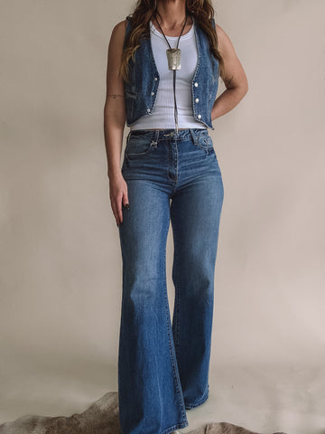 Model wearing soft high-rise wide leg western jeans with denim vest and boots.